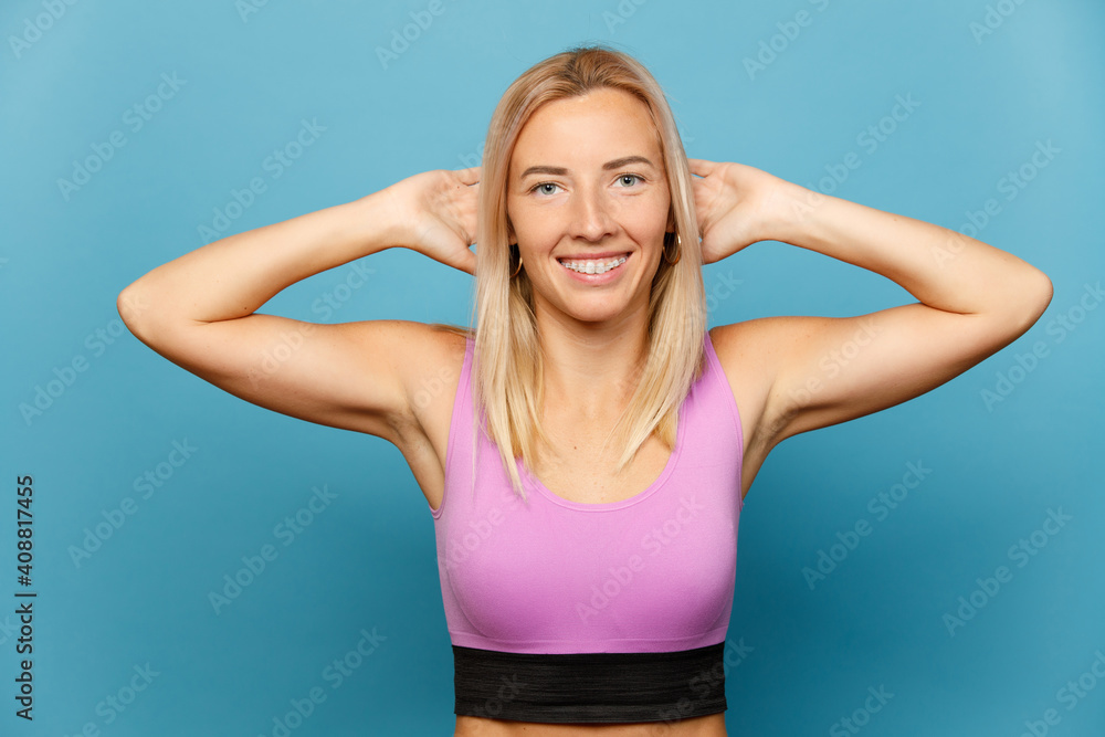 Cheerful fitness girl exercising over blue background Cheerful fitness girl exercising over blue background