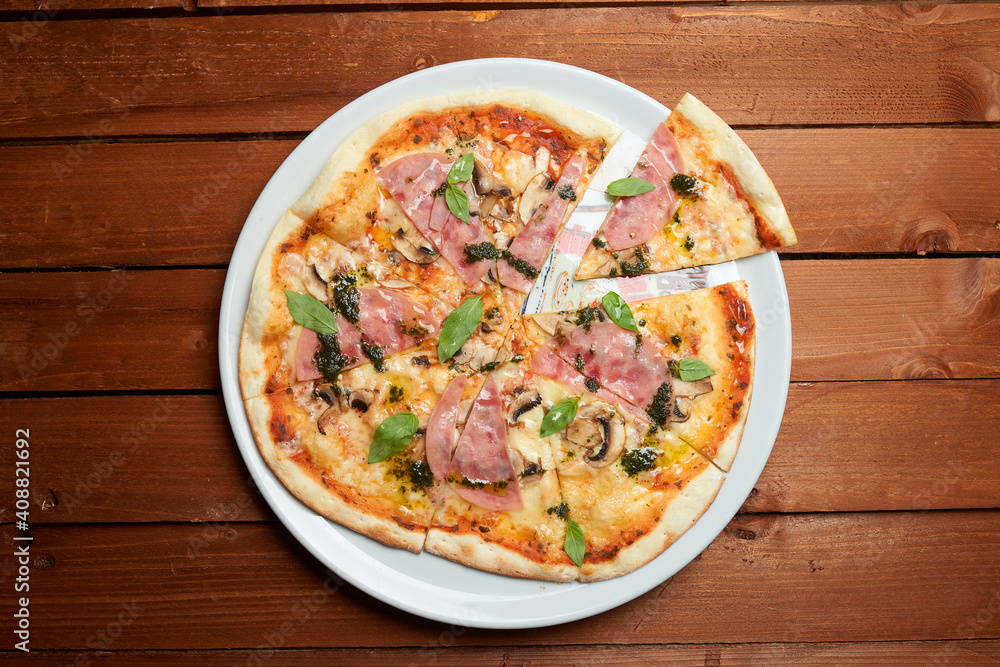 pizza with ham, mushrooms and cheese on the plate pizza with ham, mushrooms and cheese on the plate