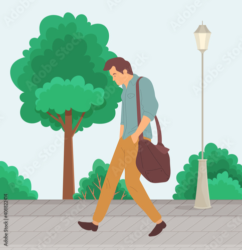 Unhappy man walks down street with a bag on the shoulder. A frustrated person goes to work. Young guy resentful man in depression outdoors. Unnerved male character in casual clothes for a walk