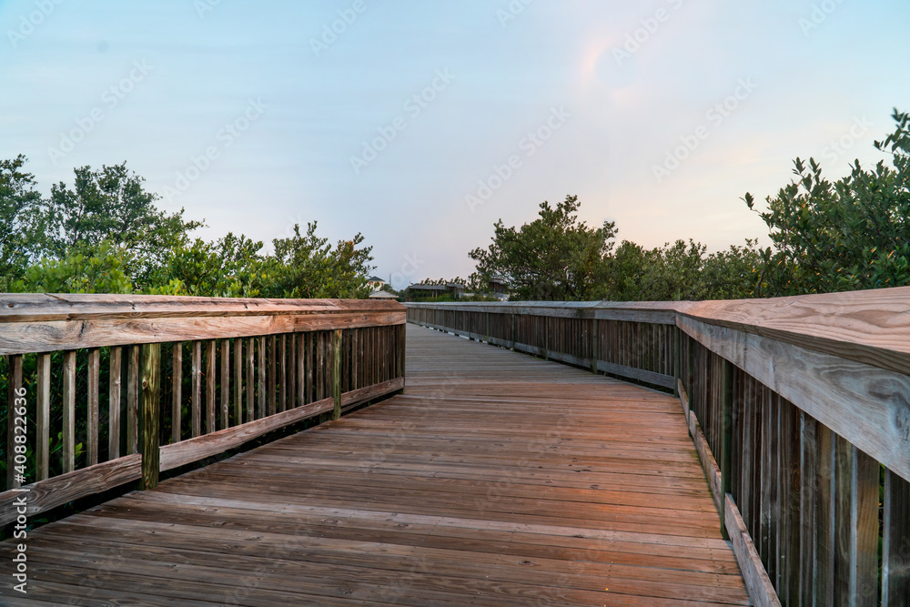 Fototapeta premium Evening with wooden walkway leading off into the distance at Hershel B King Park at Flager Florida