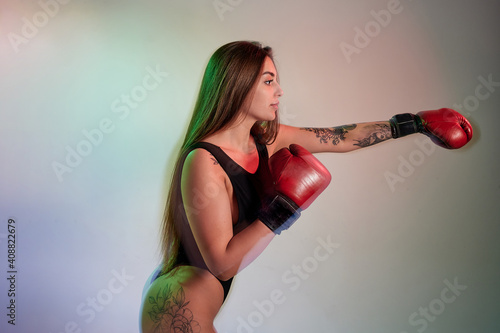Beautiful woman with the red boxing gloves. Strength and motivation.