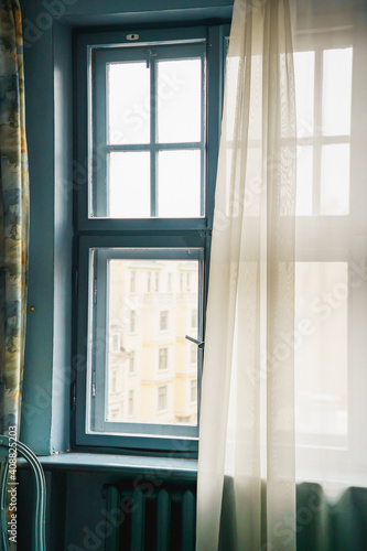 Wooden window half closed by curtain and city landscape outside  58 