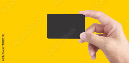 Close up of hand holding blank black card. Credit card in hand