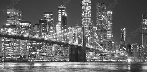 Black and white picture of Brooklyn Bridge at night, New York City, USA.