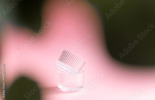  glass jars and a branch of eucalyptus on a pink background. fashion background