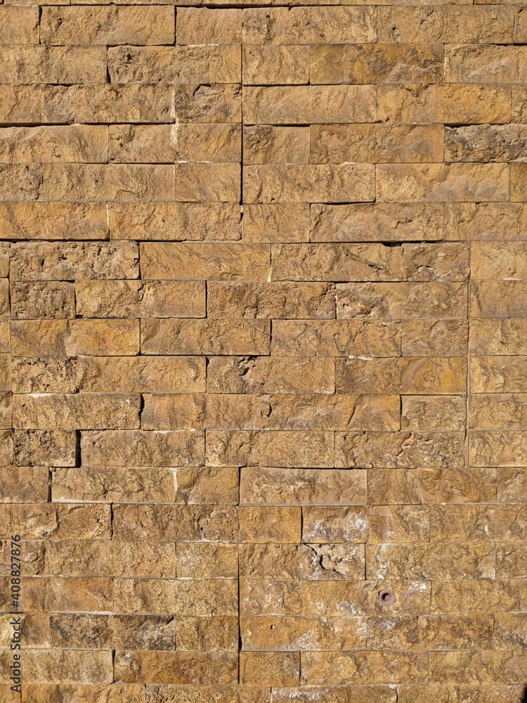 Fototapeta premium Ibiza, Spain - January 14, 2021: Yellow brick wall. Texture, material, surface, background.