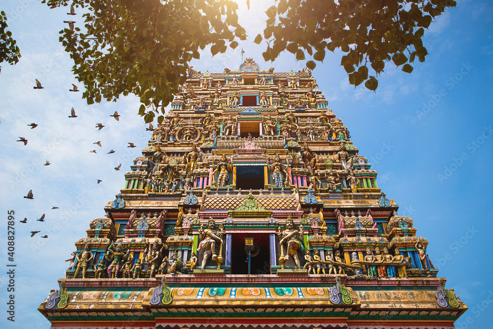 Traditional Hindu temple Kidangamparambu Sree Bhuvaneswari in India in Allapuzha (Allepi) Kerala. Tall building with colorful figures of Indian mythology and gods, flock of live birds. Tourism, travel