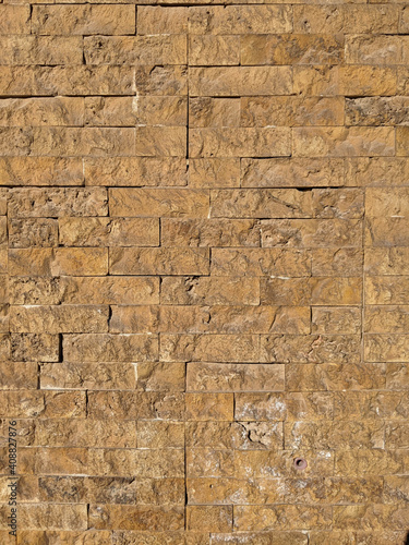 Ibiza, Spain - January 14, 2021: Yellow brick wall. Texture, material, surface, background.