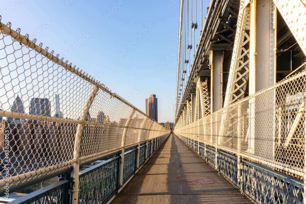Fototapeta premium Empty Manhattan Bridge Walkway in New York City. Suspension bridge that connects Manhattan with Brooklyn with walking path, subway tracks and car roads