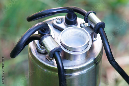 The top of the well pump with black cable. The outlet thread of the downhole pump. The pump thread is covered with a white cover.