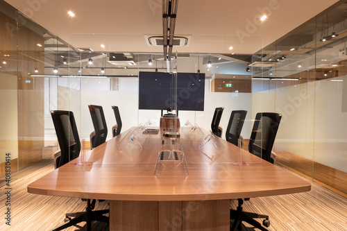 Fotografie Video conference meeting room with clear acrylic sheet separates the center on the conference table to prevent COVID-19 and face shield on the table