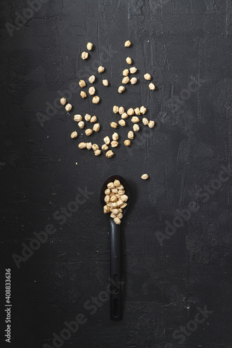 Healthy lifestyle. Black spoon with Chickpea on a wooden table.Chickpea in spoon on a black background. copy space.