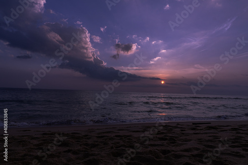 Fototapeta Naklejka Na Ścianę i Meble -  Fioletowo różowe niebo, krajobraz zachodzącego słońca na tle tropikalnej plaży i oceanu.