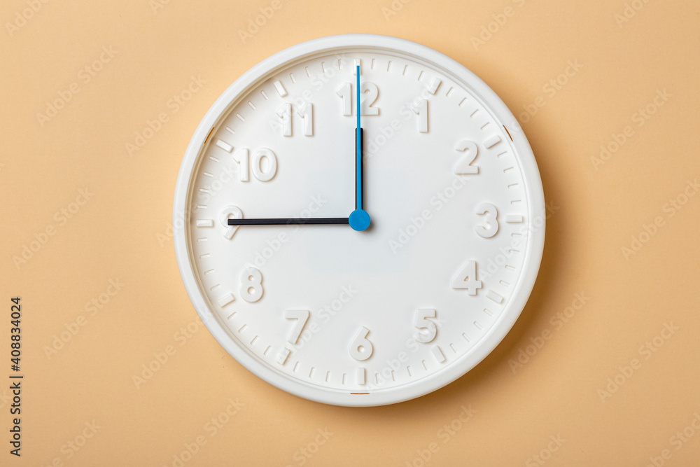 white wall clock with blue second hand show nine o'clock white wall clock with blue second hand show nine o'clock