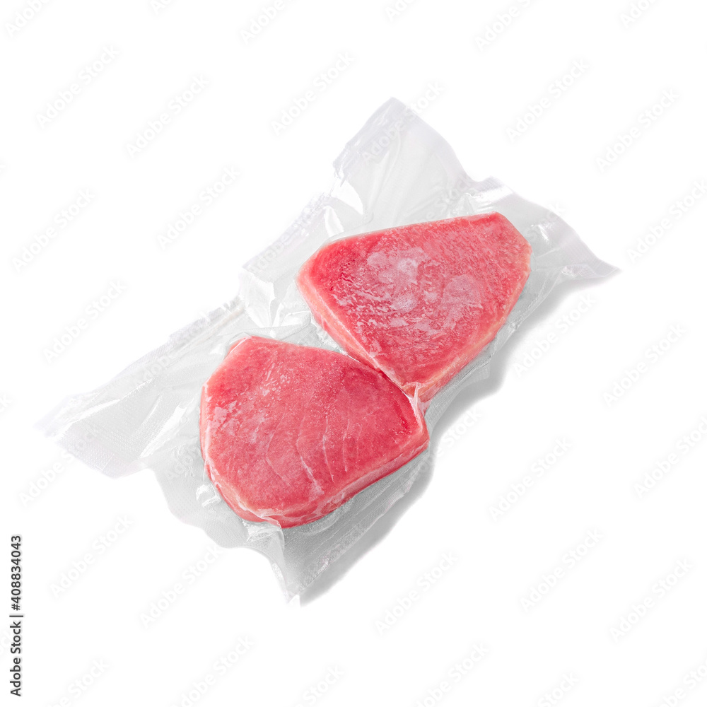 Frozen tuna steak. In plastic packaging. White background. Isolated.