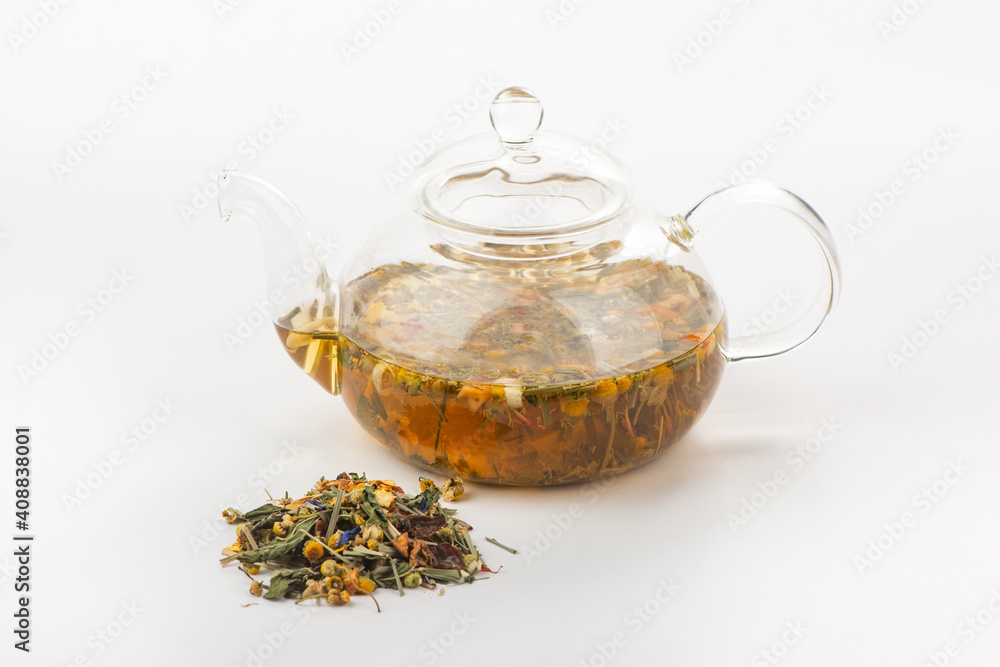 Heap of herbal tea and a glass teapot with steeped tisane Heap of herbal tea and a glass teapot with steeped tisane