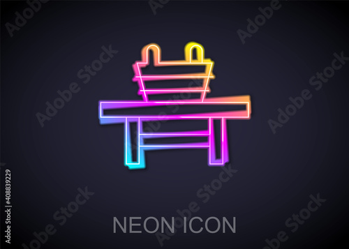 Glowing neon line Sauna bench with bucket icon isolated on black background. Vector.