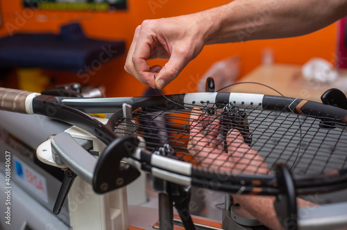 Process of stringing a tennis racket in a tennis shop, sport and leisure concept