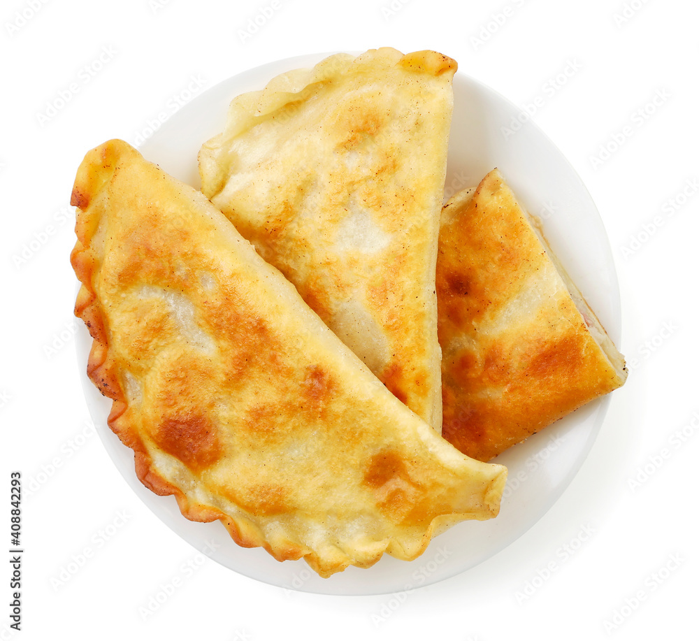 Fried cheburek on a plate on a white background, isolated. Top view Fried cheburek on a plate on a white background, isolated. Top view