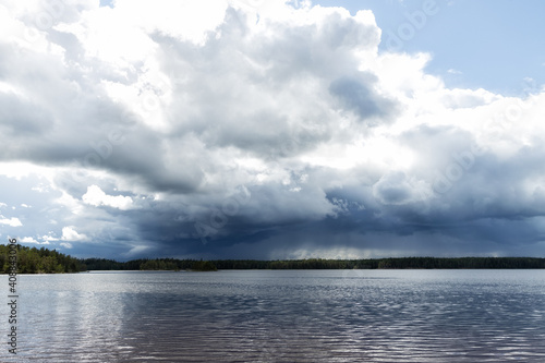 Landscape of a lake under dark storm clouds, moving waters reeds in the water. 