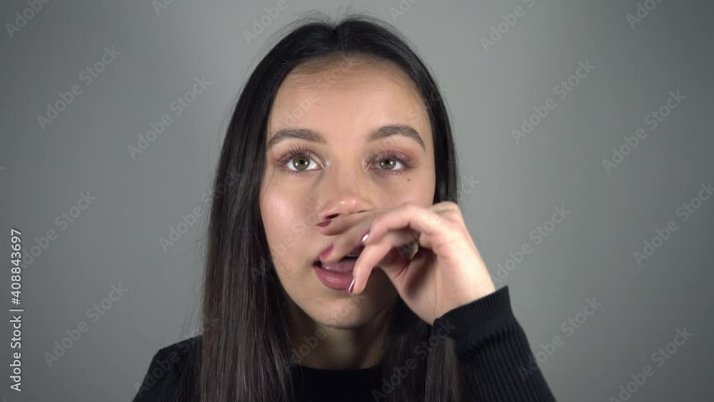Happy teenage girl annoyed with itchy nose Happy teenage girl annoyed with itchy nose