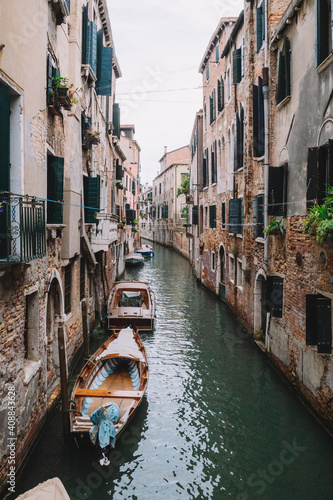Canal with boats between old houses in Venice, Italy