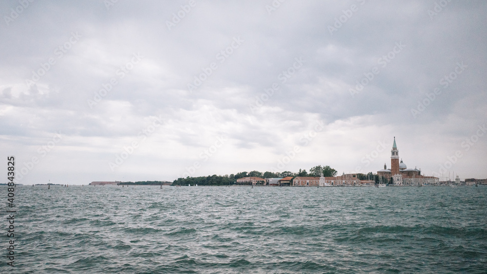 Landscape of lagoon and island of San Giorgio Maggiore under cloudy sky, Venice, Italy