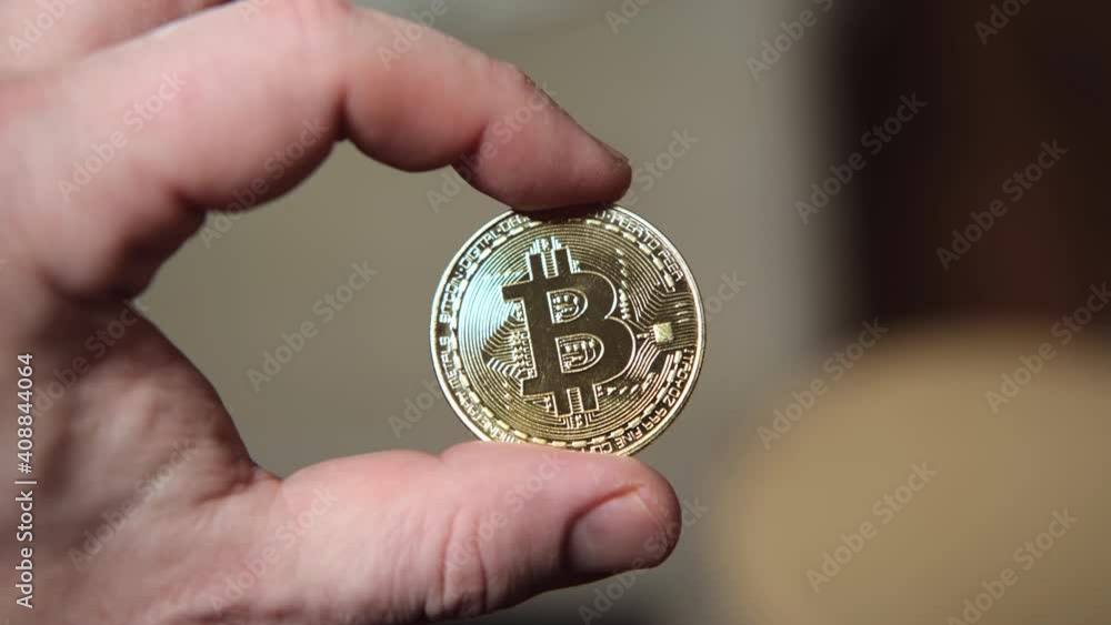 Bitcoin gold coin in a man's hand. Bitcoin gold coin in a man's hand.