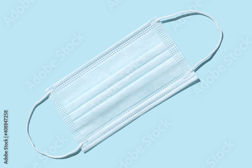 Medical surgical protective mask. On a blue background. Covering the mouth and nose. Protection concept.