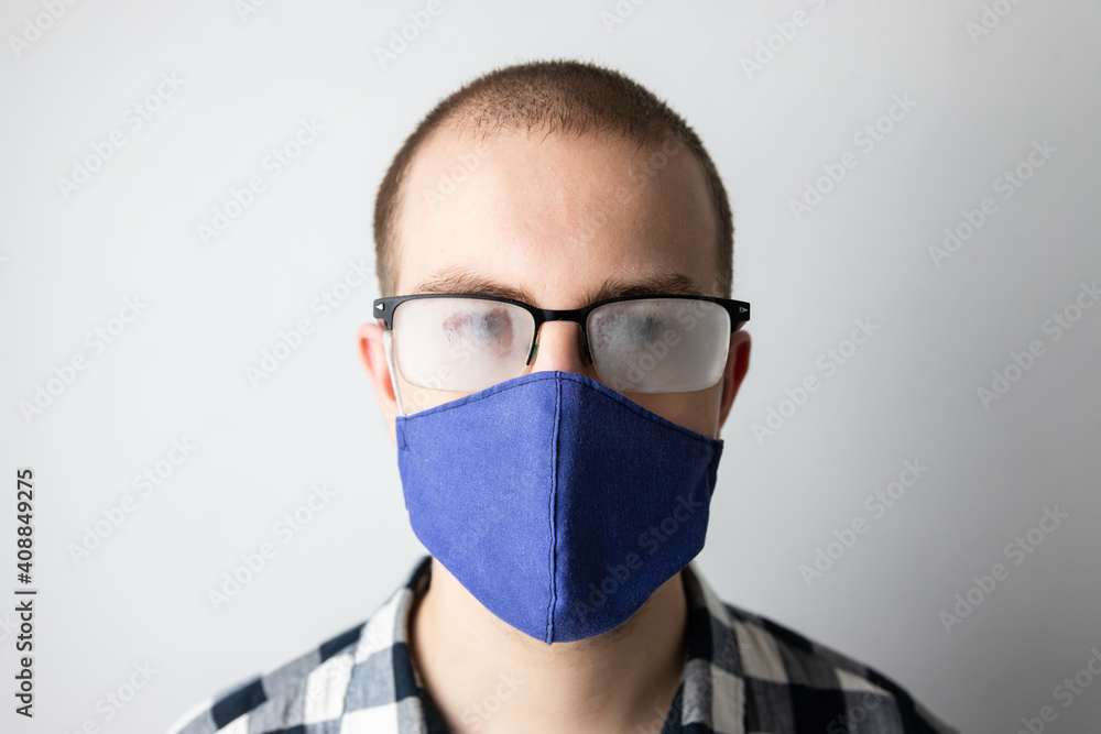 Man wearing a protective mask and fogged glasses. New habits during covid-19 pandemic. Hot breath fogs the glasses Man wearing a protective mask and fogged glasses. New habits during covid-19 pandemic. Hot breath fogs the glasses