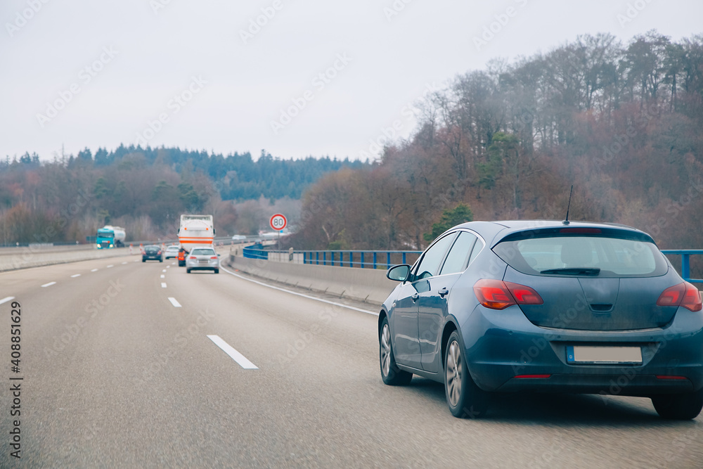 car driving on highway. Car on a highway that goes through forest. Autobahn in Germany 
