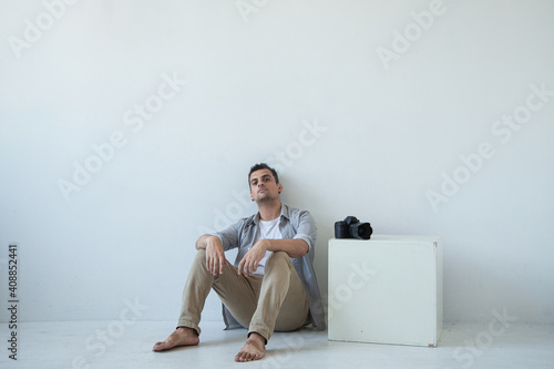 A man in a photo studio sits in a chair 