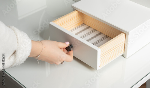 Φωτογραφία girl opens and closes the drawer of the dressing table.