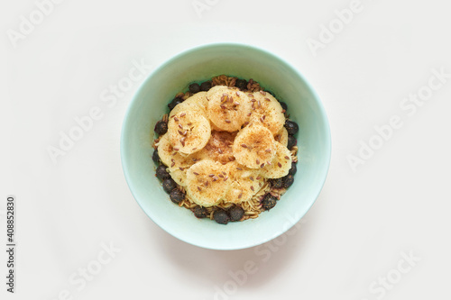 Healthy breakfast. Top view. Oatmeal with banana and flax seeds at bowl. Berry in plate. Organic meal recipe. Vegan cook. Minimalism granola. Hot porrigde with fruit