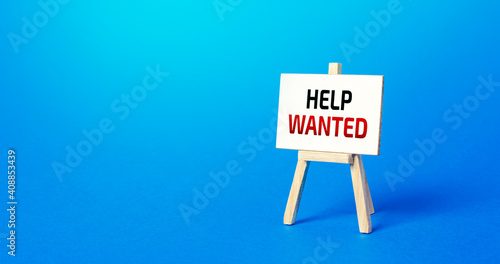 Easel with the words Help Wanted. Call for help, volunteering. Search and recruitment of new employees for work. Providing support. Drawing attention to a social problem. Advertising. Staff expansion