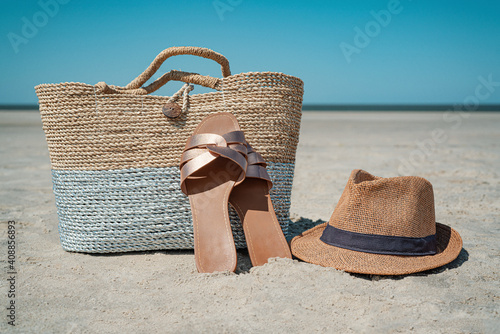  raffia bag on the beach with traw hat and sandals photo
