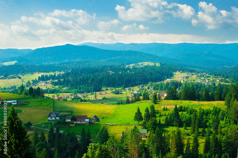 sunny landscape of mountains, fields, trees, villages and blue sky with clouds. High quality photo
