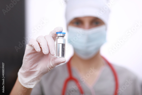 Female doctor with a stethoscope on shoulder holding COVID-19 vaccine. Healthcare And Medical concept. Development and creation of a coronavirus vaccine.