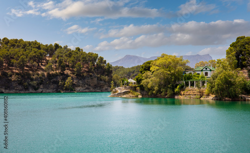 The Guadalteba Reservoir in southern Spain in summer. It's a sunny day with blue skies. In the background are the mountains of Andalusia.