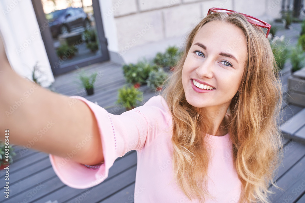 Young woman doing self portrait outside. City vacation portrait. Blogger selfie video. travel local. Alone tourist. Happy emotion. Smiling female person. Lifestyle action. Posing Young woman doing self portrait outside. City vacation portrait. Blogger selfie video. travel local. Alone tourist. Happy emotion. Smiling female person. Lifestyle action. Posing