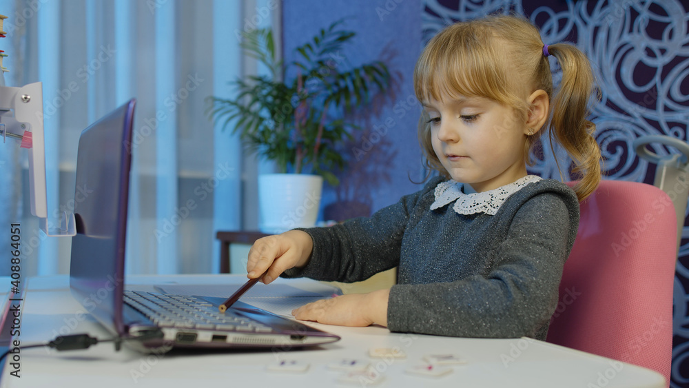 Child schoolgirl learning lessons being at home sitting at table using laptop digital computer. Portrait of kid girl distance education. Studying during coronavirus lockdown. Slow motion. 6k downscale Child schoolgirl learning lessons being at home sitting at table using laptop digital computer. Portrait of kid girl distance education. Studying during coronavirus lockdown. Slow motion. 6k downscale