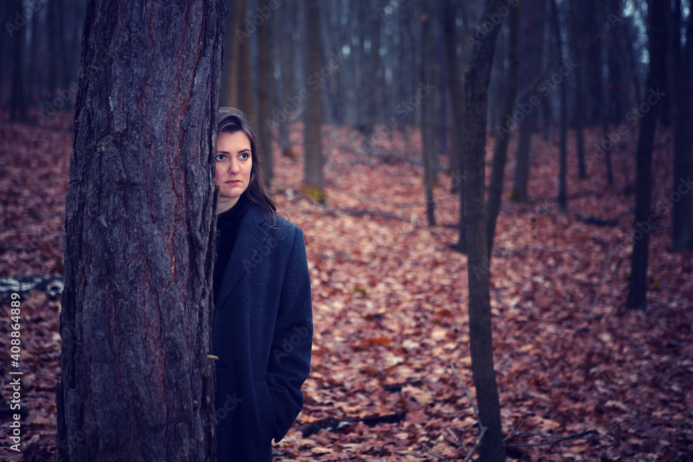 young brunette woman standing alone in the middle of a forest young brunette woman standing alone in the middle of a forest