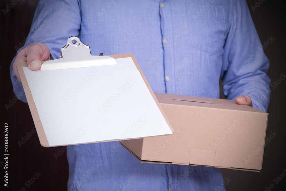 person delivers package to home with delivery note to sign. Friendly worker, high quality delivery service person delivers package to home with delivery note to sign. Friendly worker, high quality delivery service