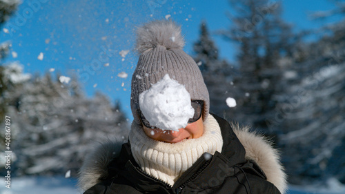 Photo PORTRAIT: Smiling female tourist gets hit in the face by a fluffy snowball