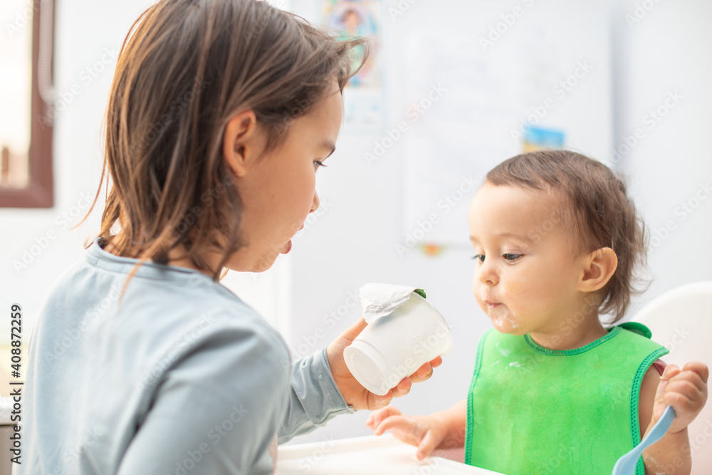 Older sister feeding her younger sister and having fun. Older sister feeding her younger sister and having fun.