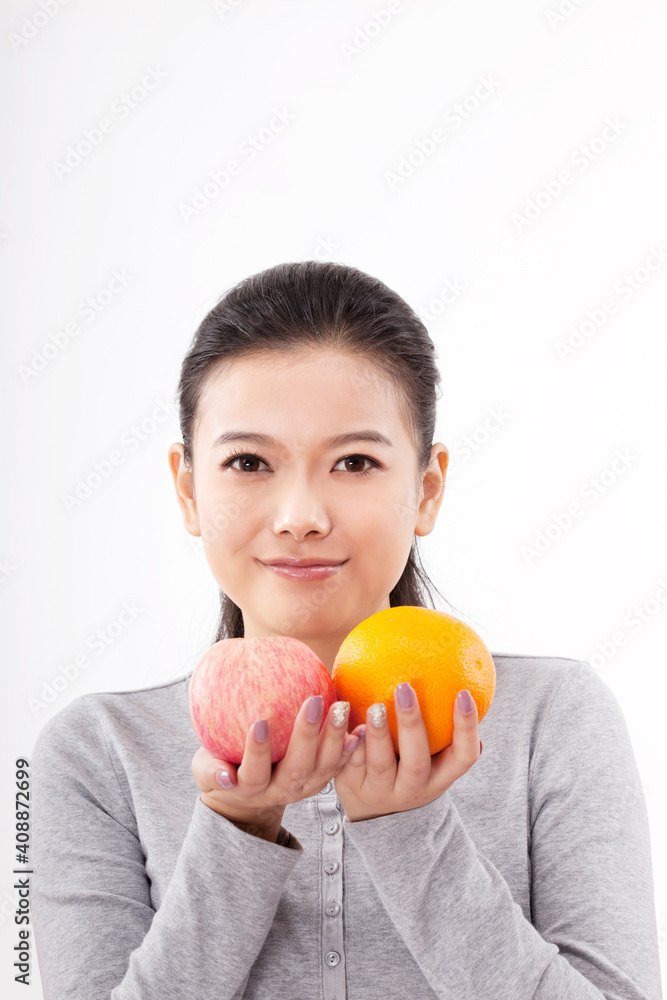 Oriental fashion woman holding red apple and orange Oriental fashion woman holding red apple and orange