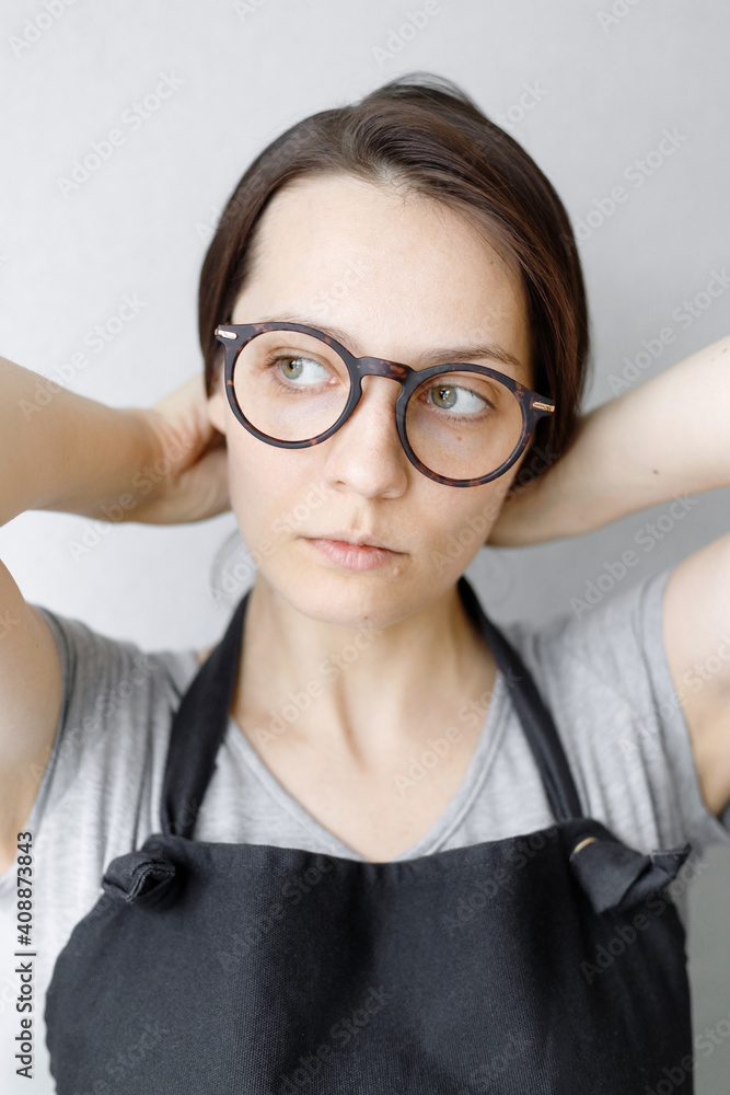 soft selective focus, portrait of a young and beautiful caucasian woman with dark hair who will put her hair back. hairstyle, home look, glasses, brooding look soft selective focus, portrait of a young and beautiful caucasian woman with dark hair who will put her hair back. hairstyle, home look, glasses, brooding look