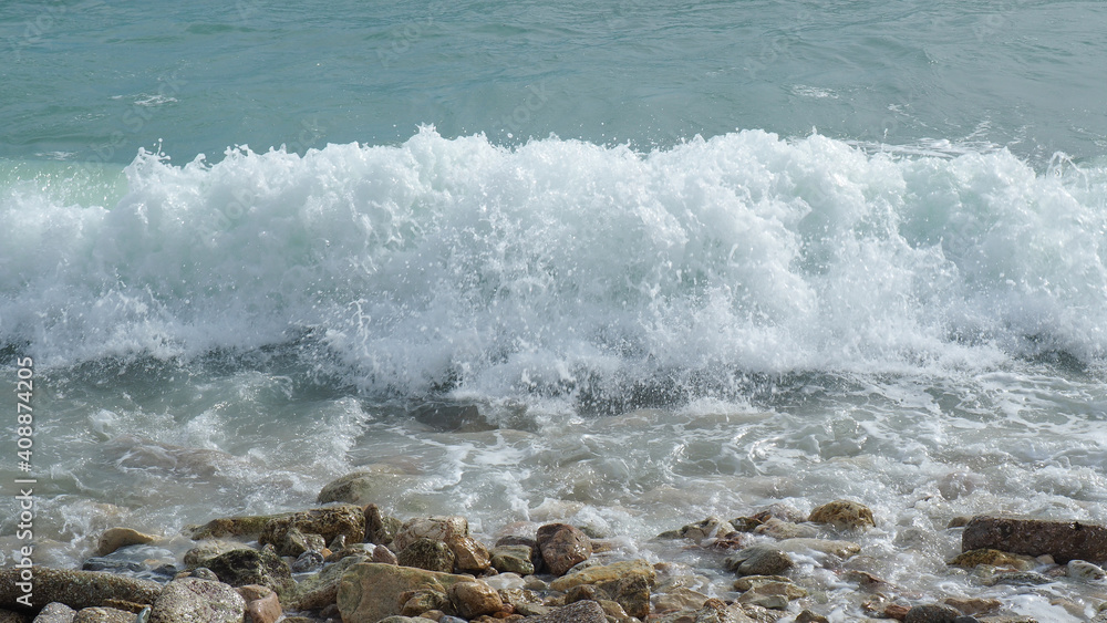 Fototapeta premium Mediterranean rocky beach with wavy sea in a cloudy morning
