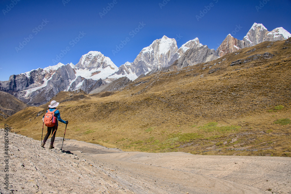 Trekker looking out at the beautiful views of Yerupajá, Siula Grande, and the high peaks of the Cordillera Huayhuash, Peru