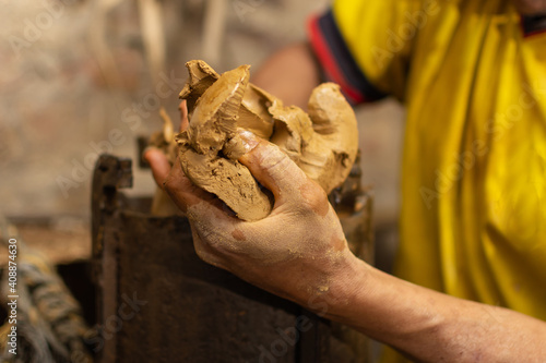 Artisan hand with raw clay. Shallow depth of field